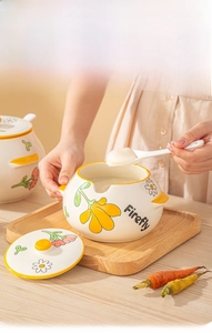 Detail of ceramic lard jar with lid and spoon featuring yellow floral patterns