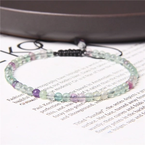 Detailed macro view of 4mm colorful natural crystal beads on a black woven cord bracelet
