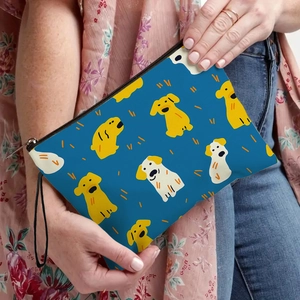 Navy blue canvas makeup bag with cartoon dog prints and wrist strap shown in hand