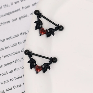 Détails de piercings tétons gothiques ailes de chauve-souris noires et zircon cœur rouge