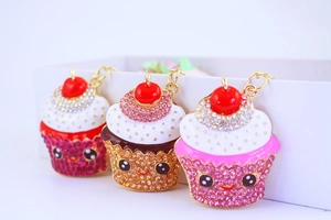 Detailed view of three glittery cupcake keychains with crystal rhinestones and cute faces