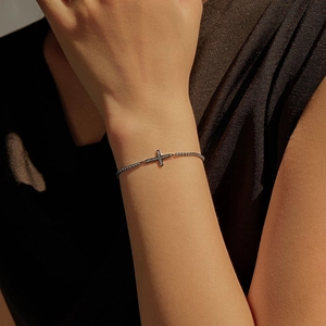 Vintage black S925 silver cross bracelet with dark gems on female model's wrist