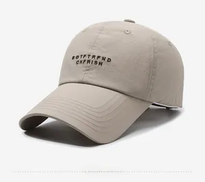 Detail view of khaki quick-dry baseball cap with dark brown embroidered lettering