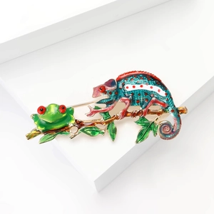 Colorful enamel chameleon and frog brooch pin in green and gold on white background