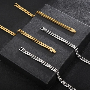 Detailed view of polished gold and silver Cuban link chains with secure square clasps