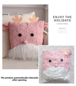 Detail of pink knitted Christmas gnome pillow with white faux fur beard and antlers