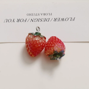 Realistic strawberry pendant made of red resin with green leaves and a metal loop