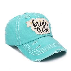 Close-up of distressed mint blue baseball cap with bride tribe embroidery patch