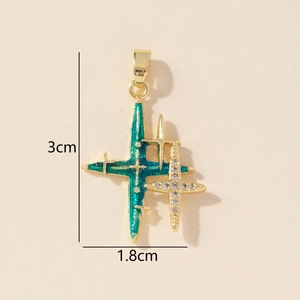 Detail shot of a star cross pendant with green enamel and zircons, dimensions 3cm by 1.8cm