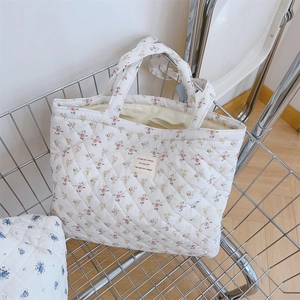 Gros plan détaillé du sac cabas matelassé à fleurs françaises avec étiquette tissée
