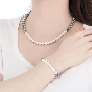 Détail de l'ensemble collier et bracelet en perles argentées porté par un mannequin
