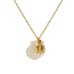 Close-up of golden sea turtle charm on white shell pendant necklace for summer beach style