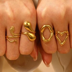 Set of four textured gold stainless steel rings including heart and organic shapes