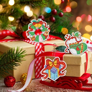 Close-up of DIY Christmas diamond painting keychains featuring festive wreath and sock charms