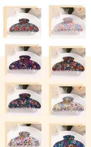 Macro shot of 8 floral pattern hair claw clips in various colors and daisy designs
