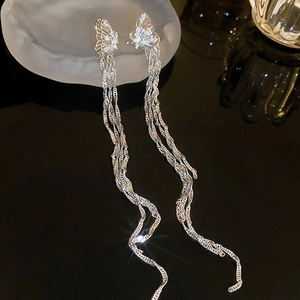 Gros plan détaillé des boucles d'oreilles papillon argentées avec zircon sur fond sombre