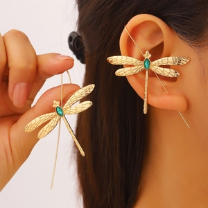 Vue macro d'un earcuff libellule vintage doré serti d'une pierre précieuse vert émeraude
