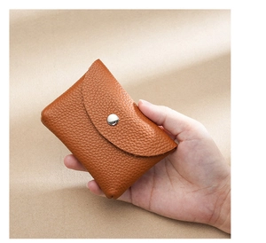 Detailed close-up of a caramel pebble grain leather coin purse with silver snap button