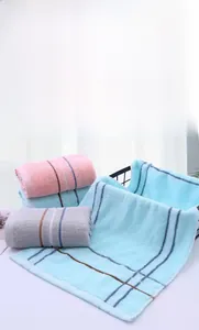Close-up of three absorbent pure cotton towels in blue, pink, and purple with stripes