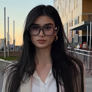 Close-up of double-bridge pilot glasses and golden earrings on a model at sunset