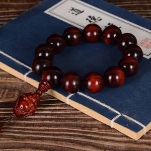 Red sandalwood beads bracelet with carved Buddha on a vintage Tao Te Ching book