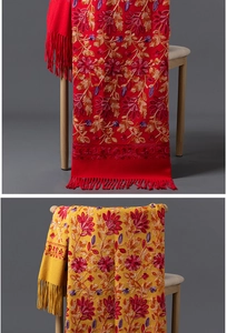 Détail de la broderie florale et des franges sur châles épais rouge et jaune doux