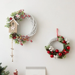 White wicker Christmas wreaths with red berries pine cones and wood cabin decor