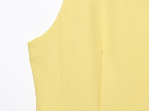 Détail du tissu jaune et des coutures de l'emmanchure d'une robe courte bouffante