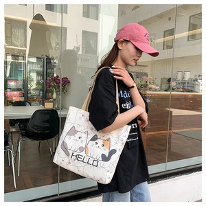 Detail of canvas tote bag with two cartoon cats and Hello text in street style