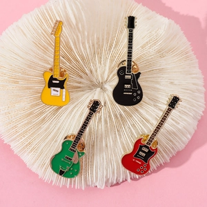 Detailed view of four colorful electric guitar enamel pins on a textured display stand