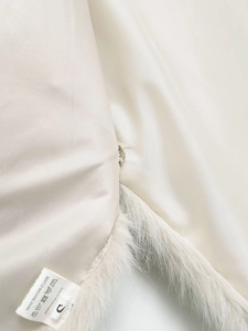 Dettaglio macro di gilet in pelliccia sintetica con fodera in seta e gancio metallico