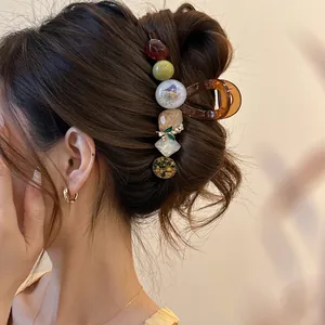 Pince à cheveux rétro ambrée avec fleurs séchées et perles sur un chignon élégant