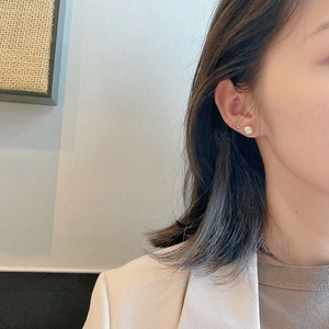 Close-up of elegant s925 silver stud earrings featuring a white bear and a pearl dot