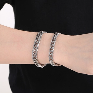 Nahaufnahme von zwei silbernen Panzerarmbändern in zwei Breiten am Handgelenk