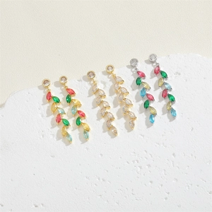 Macro shot of gold and silver leaf earrings with colorful and clear cubic zirconia stones