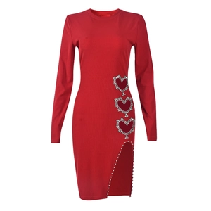 Détail de la robe rouge à manches longues avec découpes en cœur strassées et fente latérale