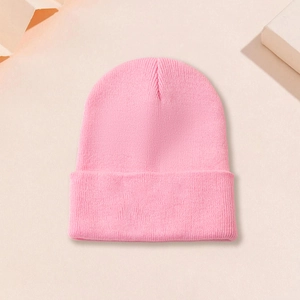 Détail du bonnet en tricot rose avec texture côtelée fine et revers élégant