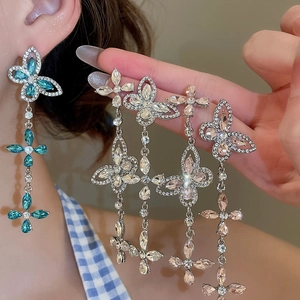 Close-up of sparkling butterfly tassel earrings with blue and pink rhinestones