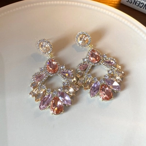 Macro shot of vintage style pink and champagne zircon tassel earrings on a ceramic dish