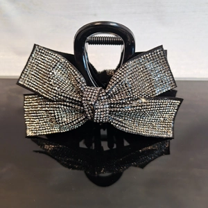 Macro shot of a black bow hair claw clip embellished with shimmering silver rhinestones