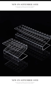 Close-up of clear acrylic tiered pencil display stand with multi-hole design on black base