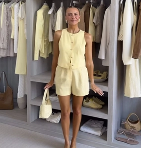 Detail view of light yellow linen vest and shorts set in a stylish walk-in closet