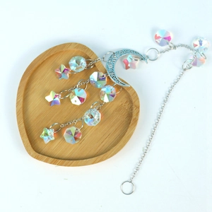 Silver crescent moon suncatcher with multifaceted iridescent crystal stars on wood tray