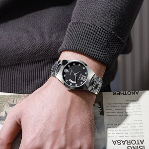 Close-up of a men's business watch with black dial and silver steel band on a model