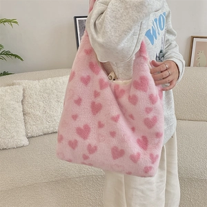 Close-up of plush heart-patterned tote bag showing soft pink faux fur texture and red hearts