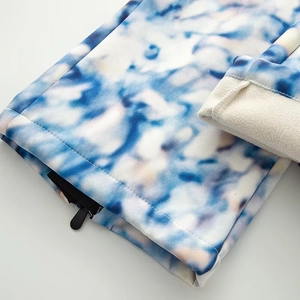 Detail of blue and white ski jacket featuring warm beige fleece lining and black zipper