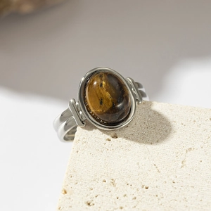 Macro shot of tiger eye stone ring set on travertine stone background showing natural textures