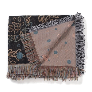 Close-up of bohemian woven camping blanket showing double-sided pattern and fringe edge