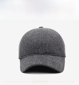 Detailed view of dark grey wool felt baseball cap with minimalist metal logo accent