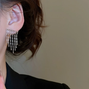 Macro shot of silver metallic fringe tassel earrings featuring a sleek minimalist drop design